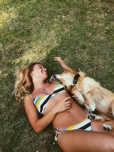 Woman with dog lying on grass 