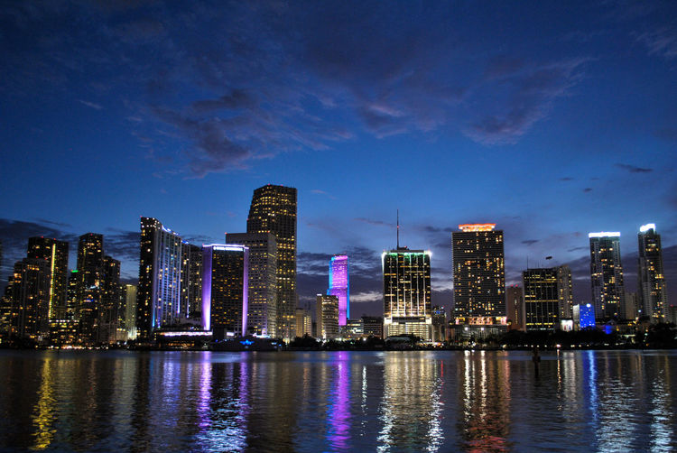 Biscayne bay by cityscape against sky at dusk