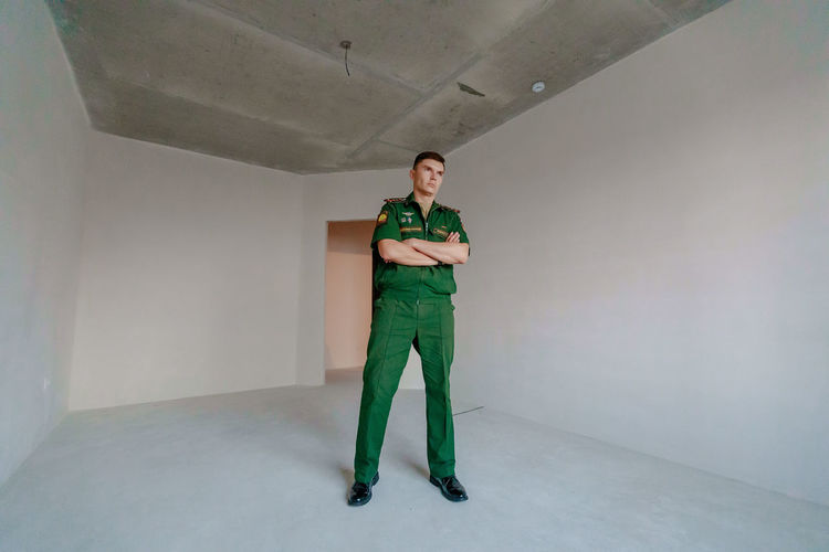 Full length of soldier standing against wall