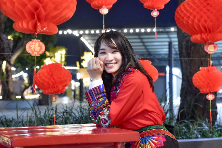 Portrait of a smiling young woman with illuminated lantern
