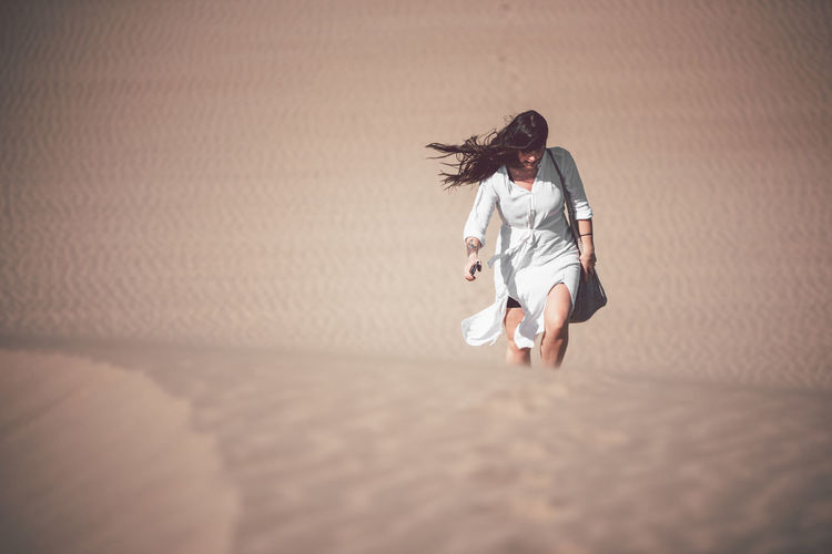 Mid adult woman walking at desert during sunny day