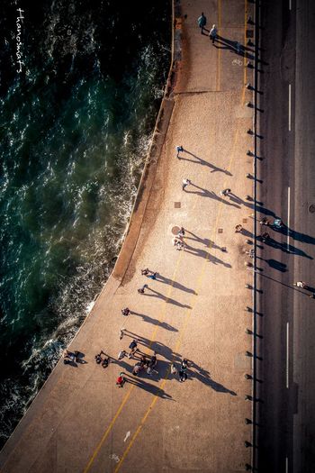 Aerial view of people on road by sea
