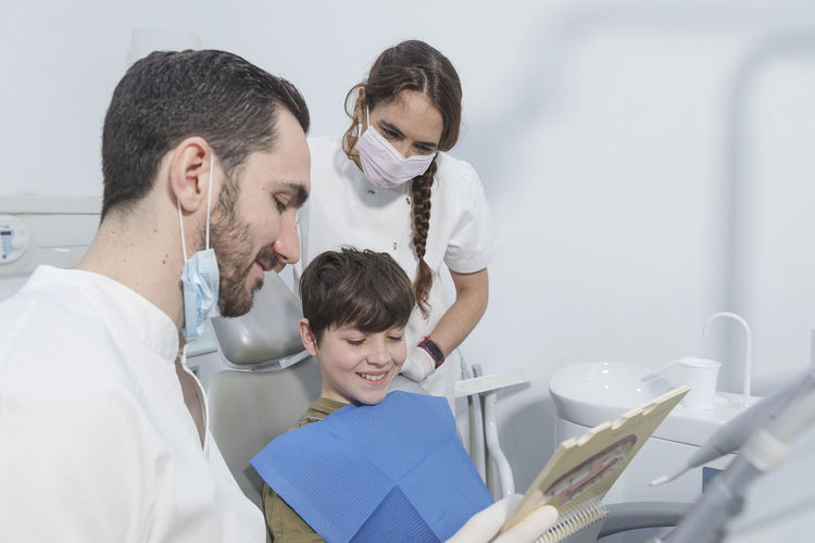 Dentist showing spiral notebook to boy in hospital