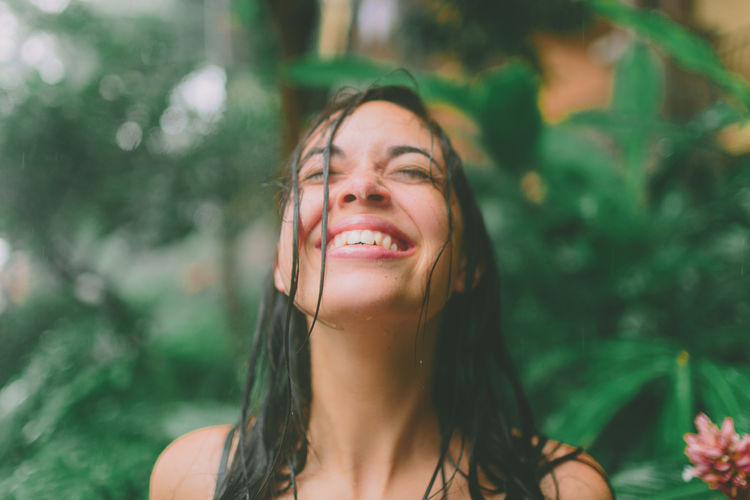 A young woman looking up to the sky as the rain falls. EyeEmNewHere Free Happy Rain Beautiful Woman Beauty Close-up Day Focus On Foreground Happiness Headshot Leisure Activity Lifestyles Looking At Camera Nature One Person Outdoors People Portrait Real People Smiling Young Adult Young Women