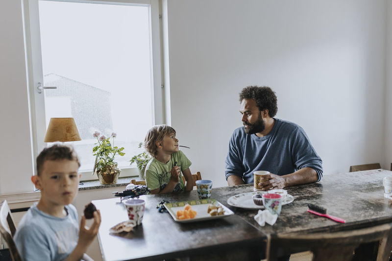 Father and children eating at table