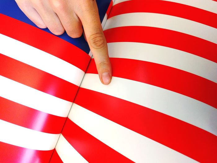 Close-up of hand pointing to american flag print