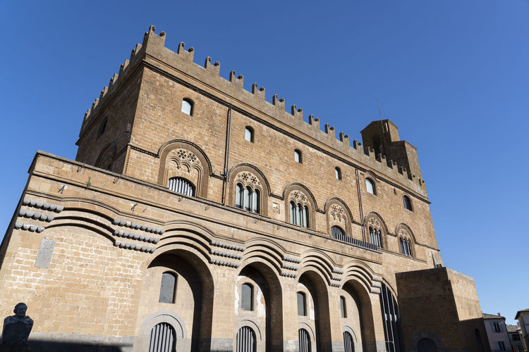 Low angle view of old building against clear blue sky