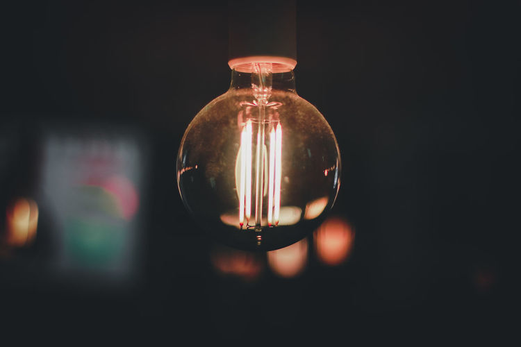 Close-up of illuminated light bulb in darkroom
