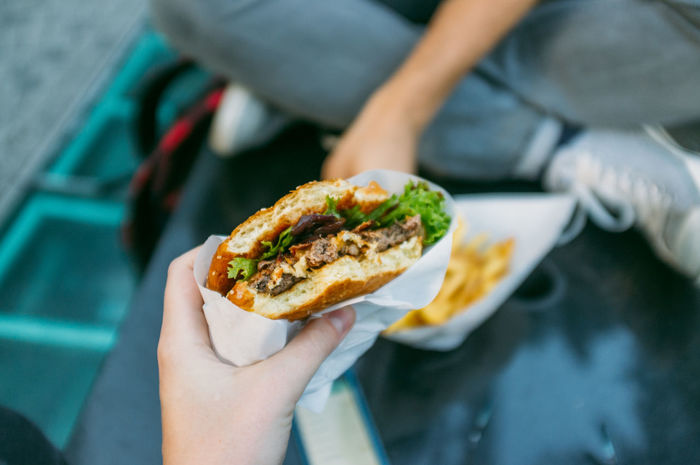 Cropped image of woman holding burger