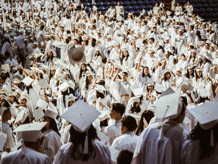 Group of students wearing white graduation gowns