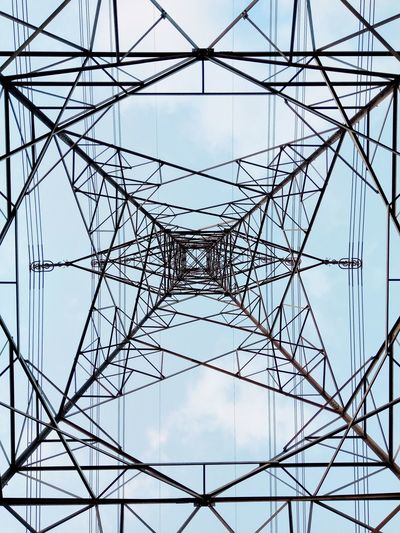 Low angle view of electricity pylon against blue sky
