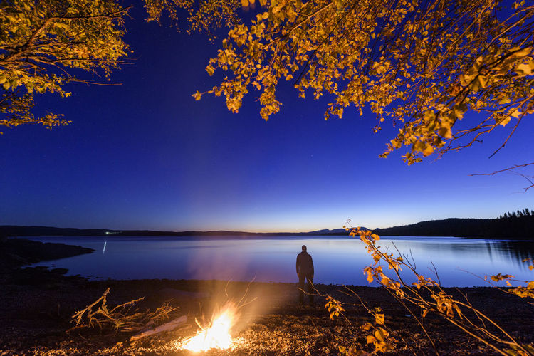 Scenic view of lake against sky at night