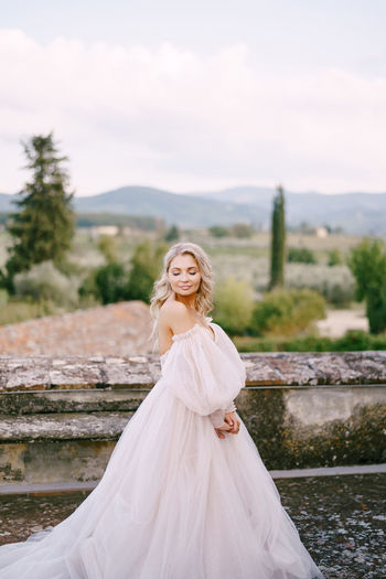 Smiling bride standing against landscape