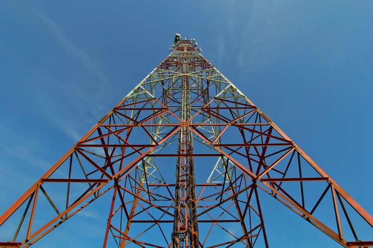 Low angle view of communication tower with blue sky