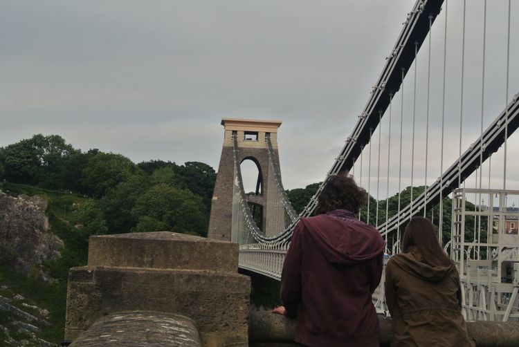 Rear view of couple on bridge against sky