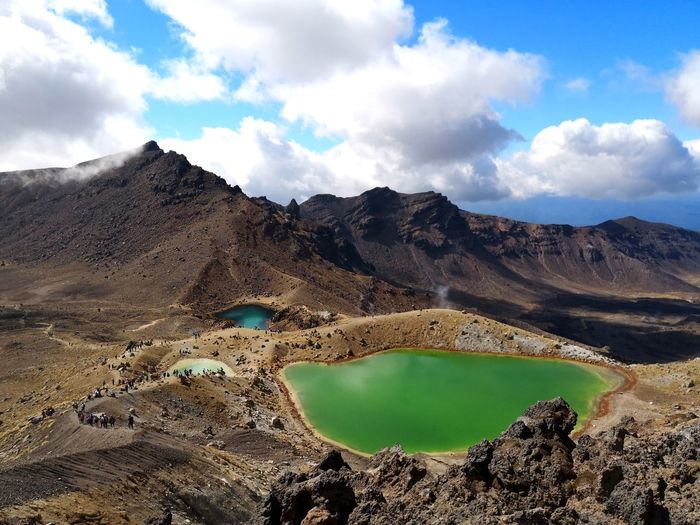 Panoramic view of volcanic lake and mountains against sky