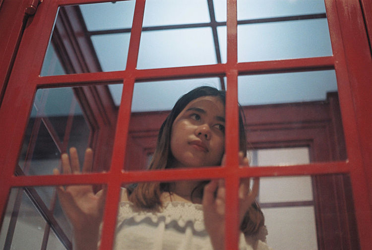 Close-up of woman looking telephone booth