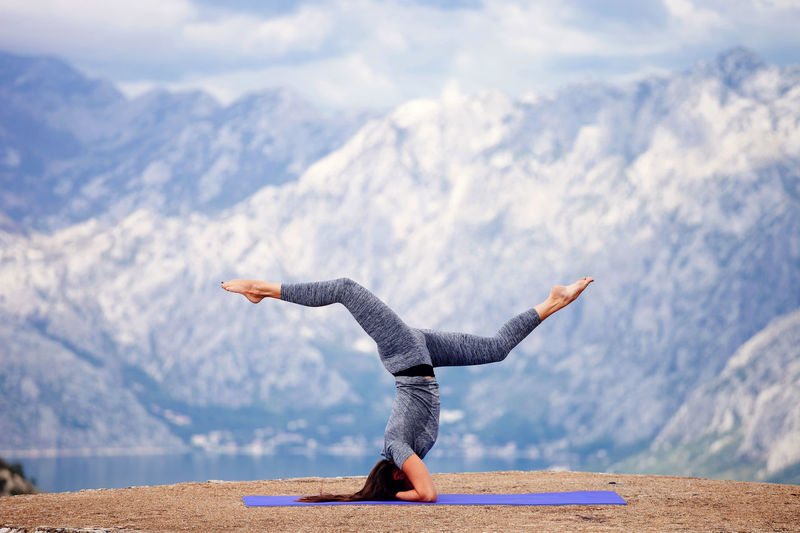 Woman practicing yoga against snowcapped mountains