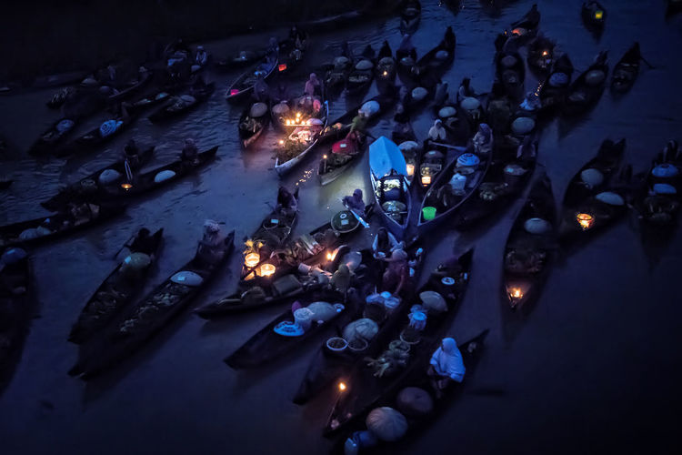 High angle view of people sailing in floating market at night
