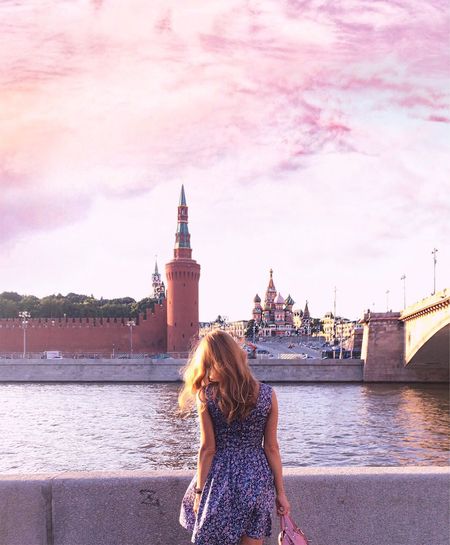 Rear view of woman standing by river against kremlin