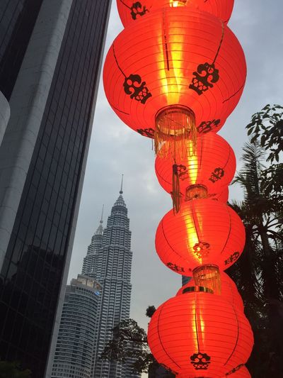Low angle view of illuminated lanterns in city against sky