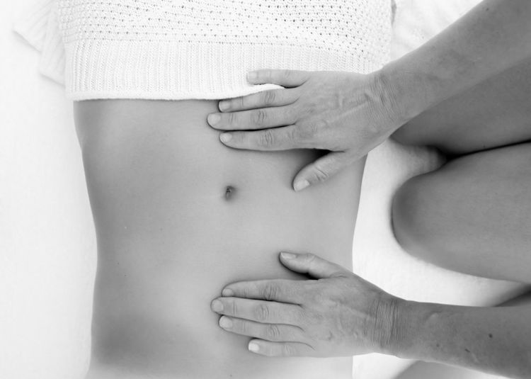 Cropped hands of woman massaging customer abdomen