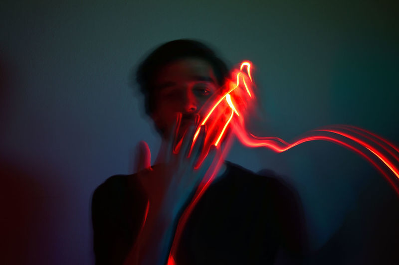 Digital composite image of man holding illuminated light