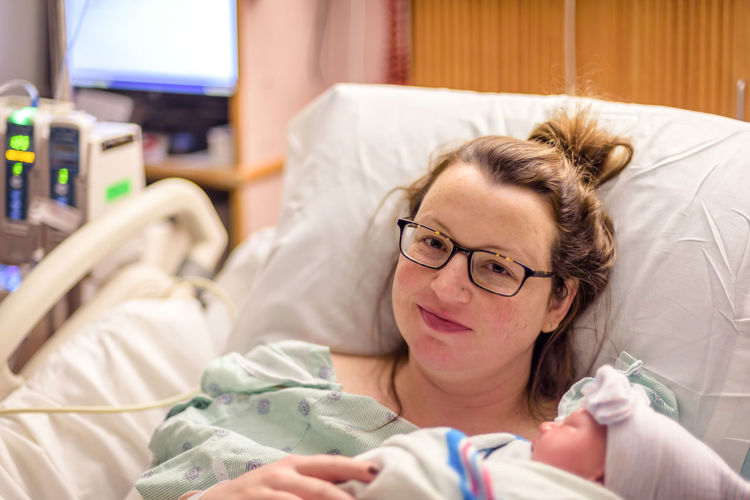 Portrait of woman with baby in hospital
