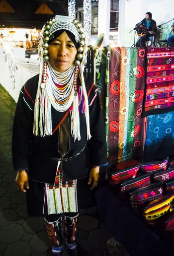 Portrait of woman in traditional clothing standing at market stall