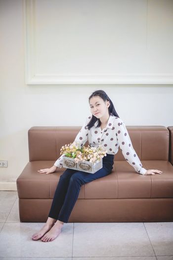 Woman sitting on tiled floor at home