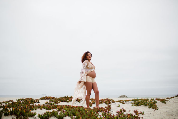 Young pregnant woman posing on beach