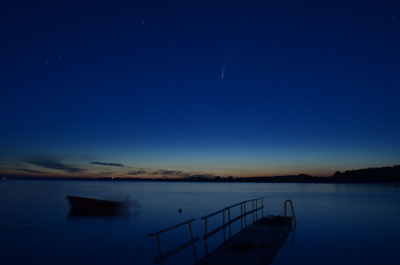 Scenic view of lake against blue sky at night