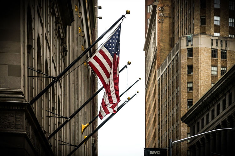 Low angle view of flag against buildings in city