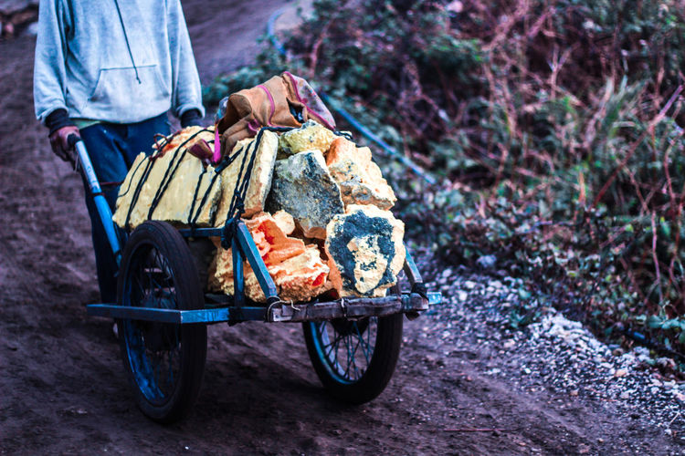 A man pushing cart full of raw sulfur, indonesia. 