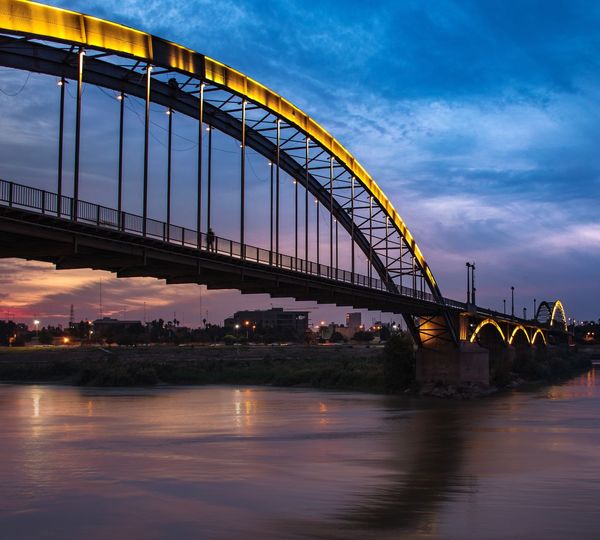 View of bridge over river against cloudy sky