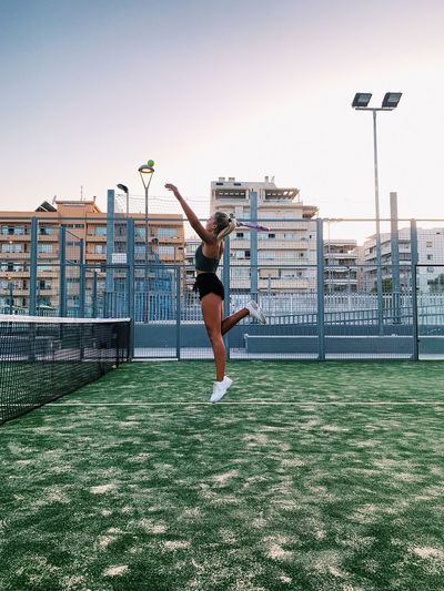 Woman playing tennis against sky