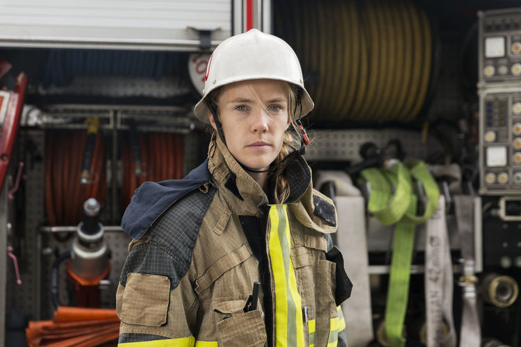 Female firefighter by fire engine