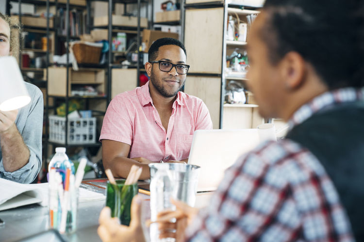 Portrait of confident businessman working with male colleagues in office