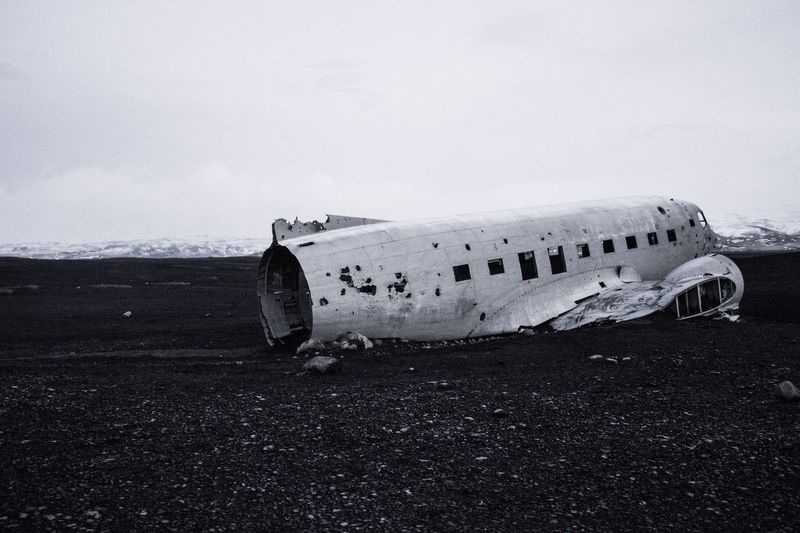 Side view of an abandoned airplane on landscape