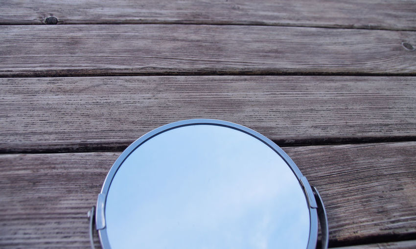 High angle view of mirror on wooden table