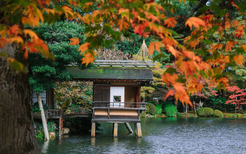 Built structure by lake and trees during autumn
