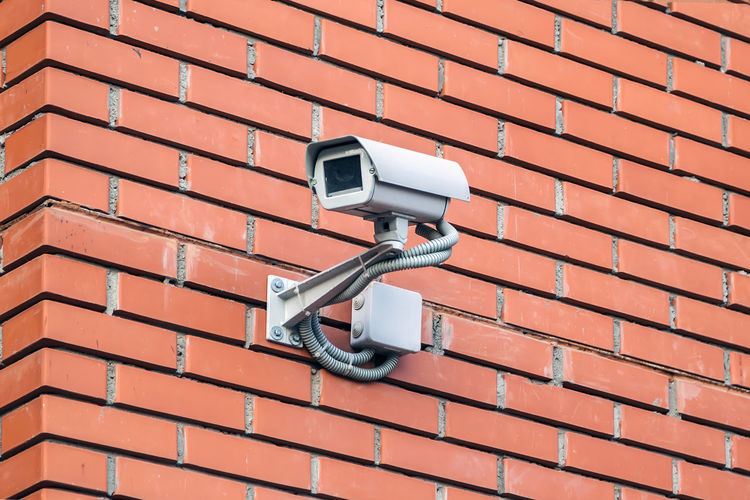 Low angle view of security camera on wall
