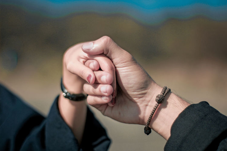 Cropped image of couple holding hands outdoors