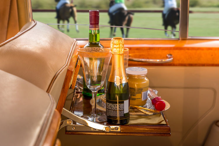 Close-up of wine bottles on table at the side of a polo match