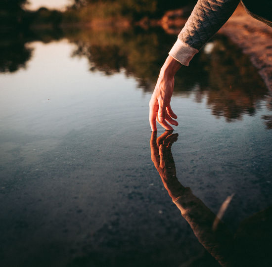 Cropped hand of person in lake