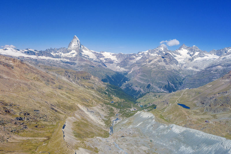 Scenic view of snowcapped mountains against clear blue sky