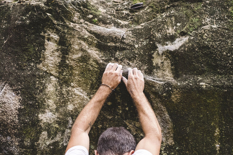 Upper part of a male climber climbing a rock