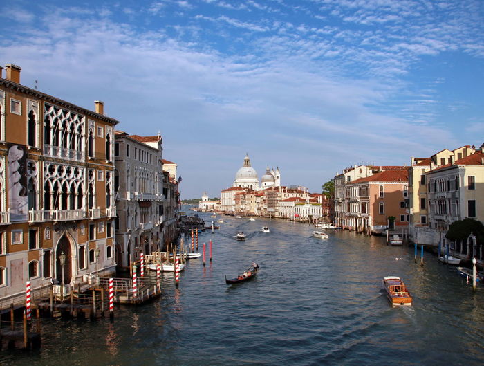 Boats in grand canal amidst buildings in city