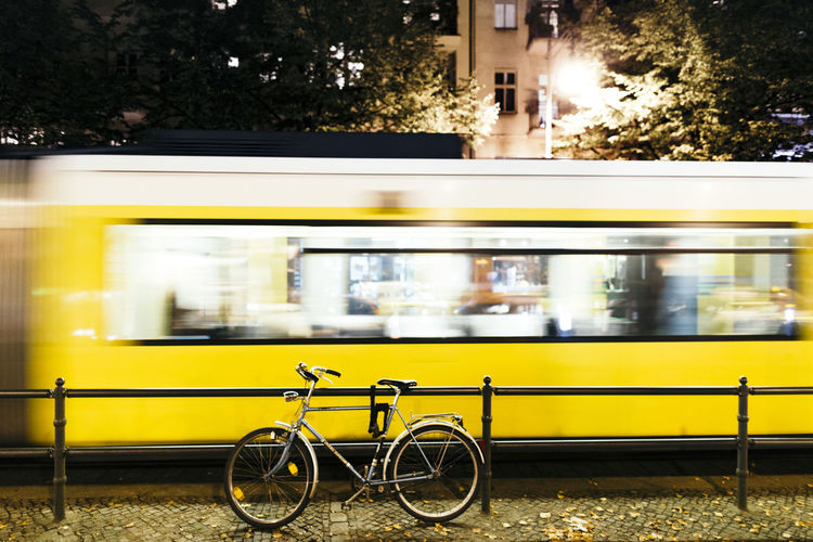 Yellow cable car by bicycle in city at night