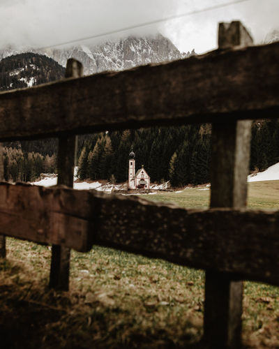 View of church in field from behind a wood fence